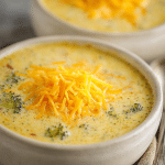 Close-up spoonful of instant pot ham cheese broccoli soup with ham, cheddar, and broccoli