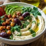 Mediterranean Quinoa Breakfast Bowl with hummus avocado chickpeas on wooden board