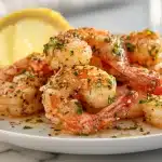 Lemon garlic butter shrimp in a cast iron skillet with parsley and lemon rounds