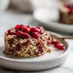 Bowl of melatonin rich cherry oatmeal with dried tart cherries and walnuts on dark wood