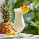 Classic pina colada in a Hurricane glass with pineapple wedge and cherry garnish