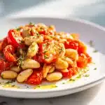 White Bean & Tomato Skillet in a cast iron pan with parsley and Parmesan garnish