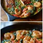 Cast-iron skillet with seared Cajun shrimp and salmon fillets in a creamy garlic sauce, with wilted spinach and red bell peppers.