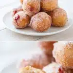 Golden fried Jam filled donut holes, one split open revealing strawberry jam filling, sprinkled with cinnamon sugar on a white surface.